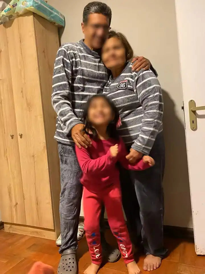 Une jeune fille portant un ensemble de pyjama à manches longues rose vif avec pantalon assorti orné d'inscriptions bleues sur les côtés.